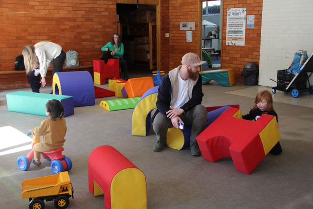 Parents and children exchange toys and smiles at toy library opening